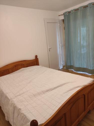 a bedroom with a large bed with a blue curtain at Logis vouté les hirondelles in Rogna