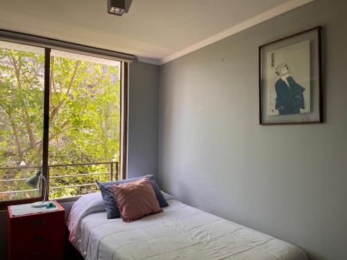 Un dormitorio con una ventana y una cama con almohada. en Comodidad y perfecta ubicación, en Santiago