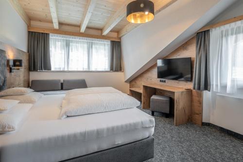 una camera da letto con due letti e una TV a schermo piatto di Alt-Kaisers a Sölden