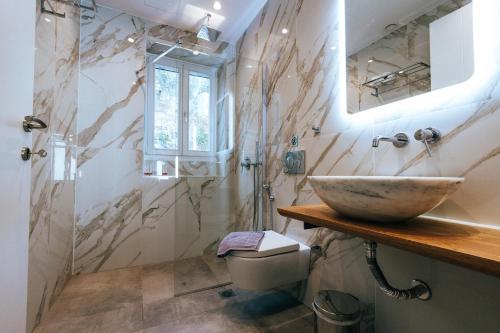 un bagno con lavandino e specchio di La Villa, independent villa with pool and jacuzzi a Chorto