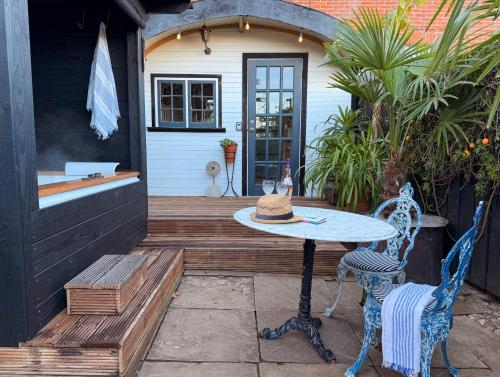 a patio with a table and two chairs at The Cabana Luxury Award Winning Tiny Home with Hot Tub and Private Garden 2 mins Walk to Ryde Beach in Ryde