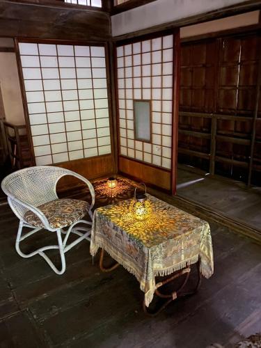 a room with a table and a chair at Tsumugu dom in Ueda