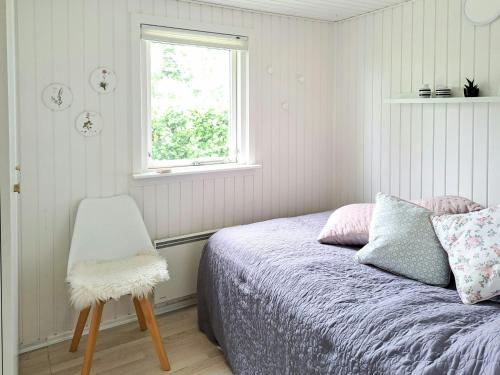 VejlbyskovFamily Holiday Home Close To Beach At Vejlby Fed的一间卧室配有一张带椅子的床和一扇窗户