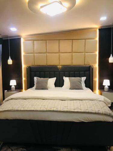 een slaapkamer met een groot bed met witte lakens en kussens bij Omnia Luxe Villa in Pānigata