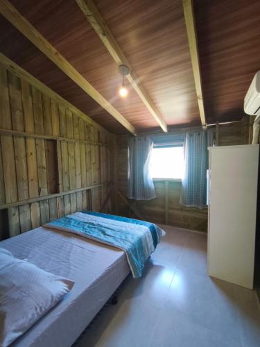 a bedroom with two beds and a window in it at Apartamento de 2 Quartos para 4 Pessoas - 5 min da Praia in Garopaba
