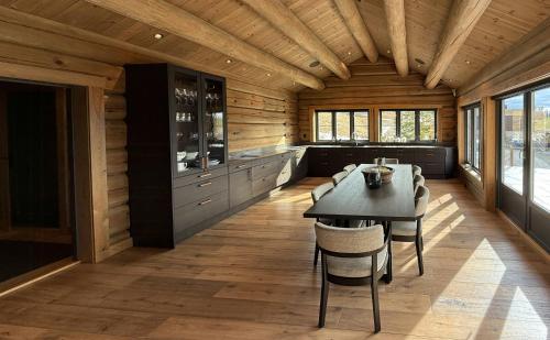a dining room with a table and chairs at Luxurious Log Cabin At Mostertoppen in Øyer