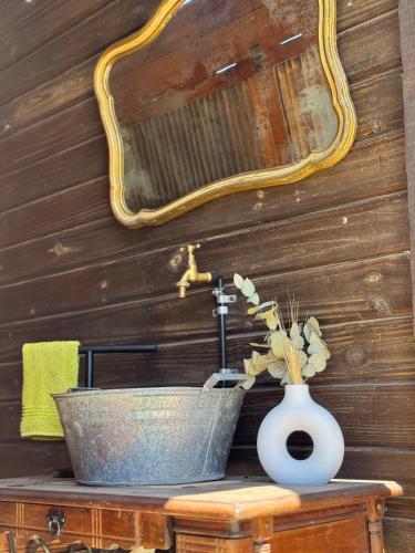 a bathroom with a sink and a vase on a table at Quinta La Berna in Etchegoyen