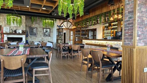 a restaurant with tables and chairs and a bar at Hotel & Restaurant Mulliri me Erë in Rahovec