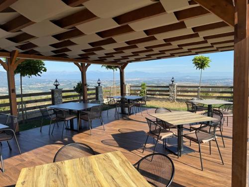a patio with tables and chairs and a view of the ocean at Hotel & Restaurant Mulliri me Erë in Rahovec