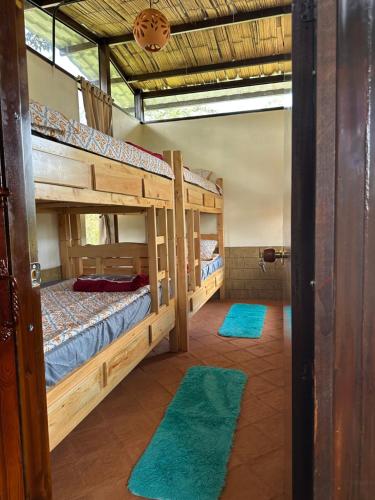 two bunk beds in a room with green rugs at Villas de Sutamarchan in Sutamarchán