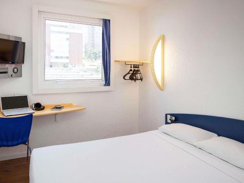 une chambre avec un lit, un bureau et une fenêtre dans l'établissement ibis budget Sao Paulo Morumbi, à São Paulo