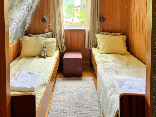 um pequeno quarto com duas camas e uma janela em Historic Cabin By Lærdal River em Tønjum