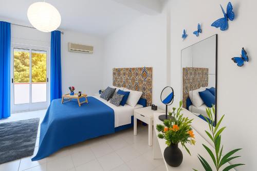 une chambre bleue et blanche avec un lit et des papillons bleus dans l'établissement "Stella Home " Perfetto per le tue vacanze in Sicilia sul Golfo di Castellammare ! Relax a pochi mt dal mare per Amici e Famiglie, à Alcamo Marina