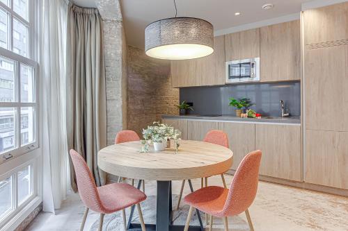 a dining room with a wooden table and orange chairs at Metropolitan Boutique in A Coruña