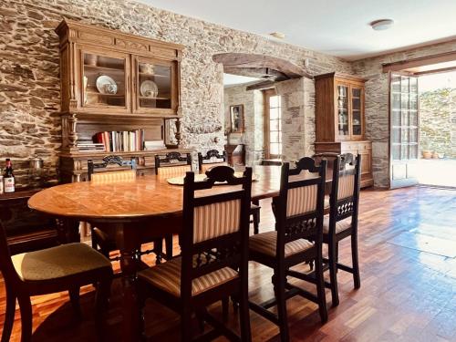 ein Esszimmer mit einem Holztisch und Stühlen in der Unterkunft Prioral Countryside Villa in Miño