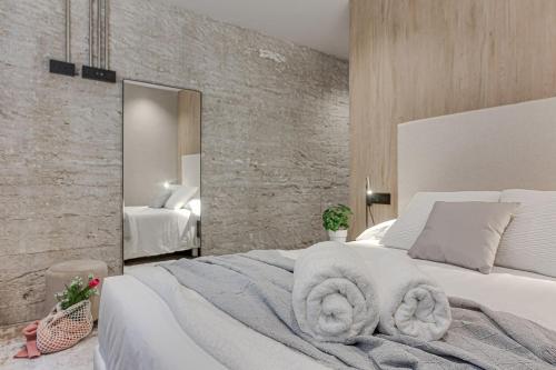 een slaapkamer met een wit bed met handdoeken erop bij Metropolitan Boutique in A Coruña