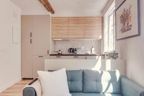 a living room with a blue couch and a kitchen at Old Quarter Boutique in A Coruña