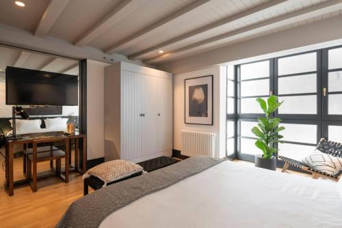 a bedroom with a large white bed and a desk at ART Boutique in A Coruña