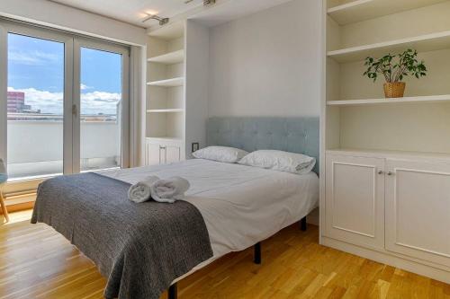 a bedroom with a bed and a large window at Blue Ocean Penthouse in A Coruña