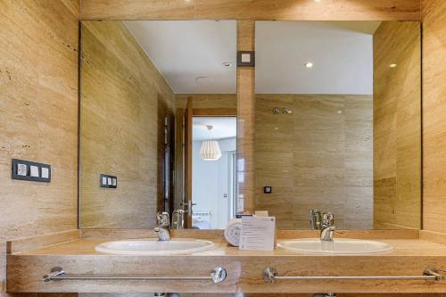 a bathroom with two sinks and a large mirror at Blue Ocean Penthouse in A Coruña