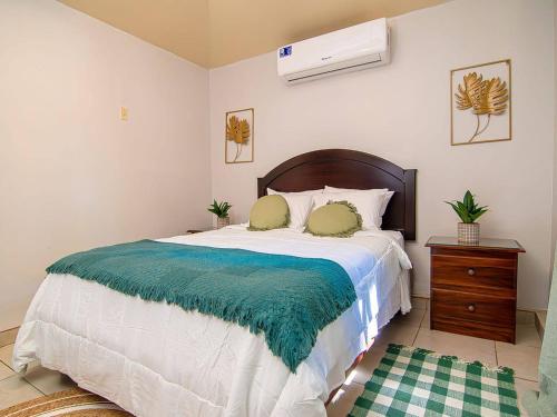 um quarto com uma cama grande com um cobertor azul em Bonsai Rentals - West Bay Private Rooms em West Bay