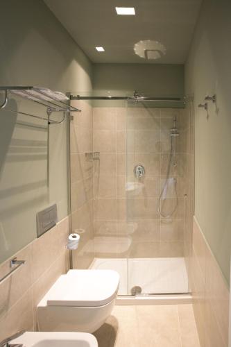a bathroom with a shower and a white toilet at Corte Olea Resort in Paceco