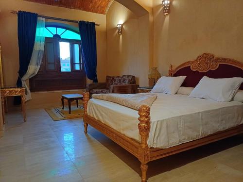 a bedroom with a bed and a chair and a window at Iteru inn villa in Fayoum