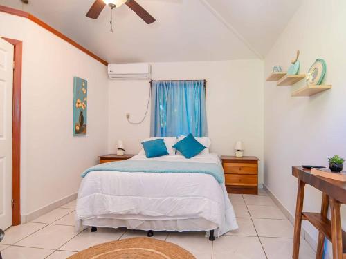 a bedroom with a bed with blue pillows and a window at West Bay Room, Pool, Fridge, Shuttle, Dive in West Bay