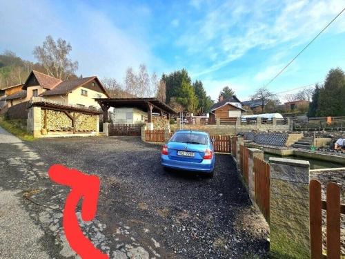 Niebieski samochód zaparkowany przed domem w obiekcie Čapí hnízdo se saunou w mieście Drnovec