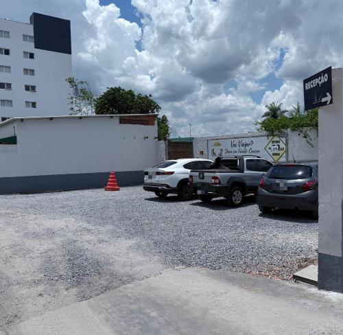 ein Parkplatz mit vor einem Gebäude geparkten Autos in der Unterkunft Hotel Express - Leva e busca no aeroporto grátis 24 horas in Várzea Grande