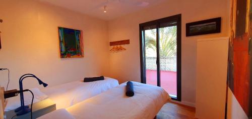 Cala LlombardsVilla Embarcadero的有窗户的房间里有两张床