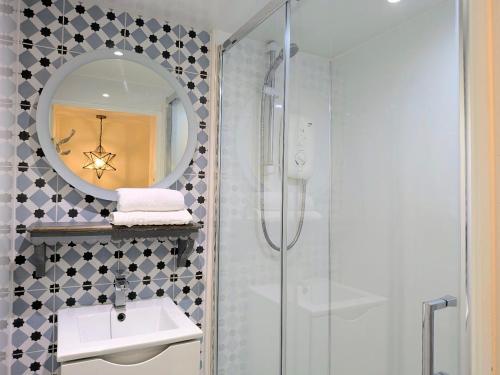 ein Badezimmer mit Dusche, Waschbecken und Spiegel in der Unterkunft Normanby Cottage Runswick Bay in Runswick