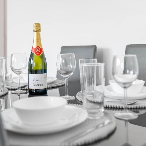 a bottle of wine sitting on a table with glasses at 2 Bed Apartment - Sleeps 3 - Parking - Cradley Heath 54C in Netherton