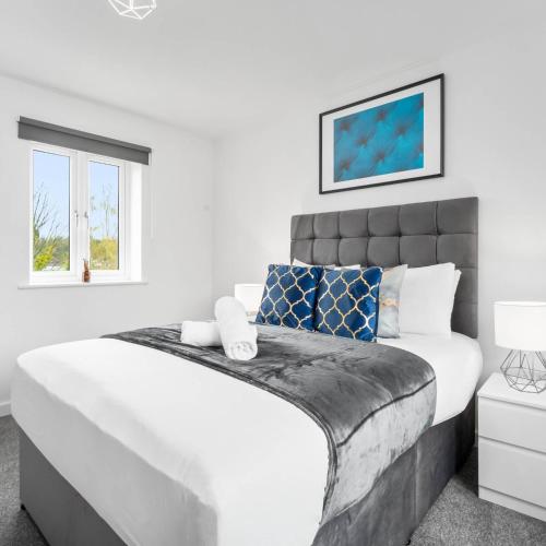 a white bedroom with a large bed and two windows at 2 Bed Apartment - Sleeps 3 - Parking - Cradley Heath 54C in Netherton