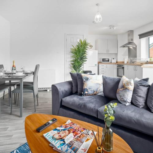 a living room with a blue couch and a table at 2 Bed Apartment - Sleeps 3 - Parking - Cradley Heath 54C in Netherton