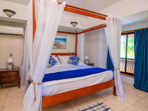 ウェスト・ベイにあるBonsai rentals - West Bay Private Roomsのベッドルーム(天蓋付きベッド1台、窓付)