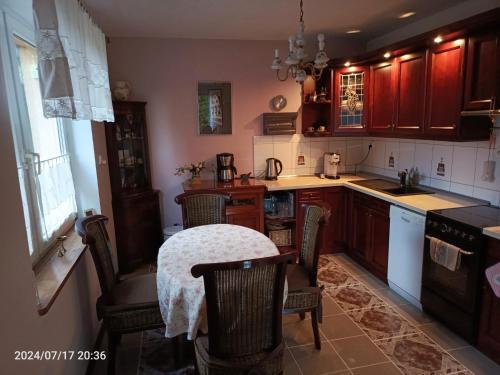 eine Küche mit einem Tisch, Stühlen und einer Theke in der Unterkunft Kaschubische Schweiz : Oase der Entspannung in Łyśniewo