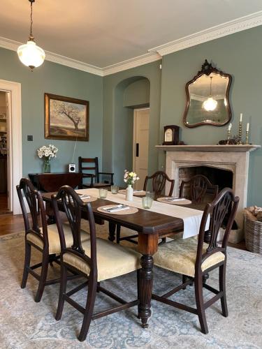 Un comedor con mesa y chimenea. en The Green, en Wingfield