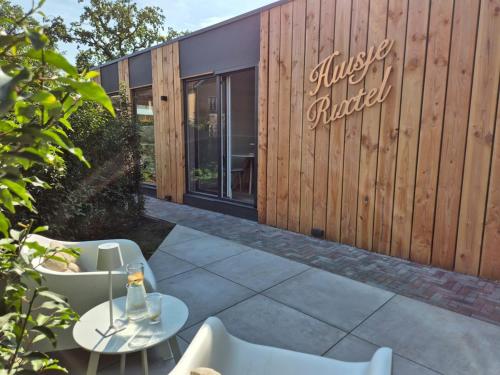 a patio with a table and chairs in front of a building at Huisje Rixtel in Aarle-Rixtel