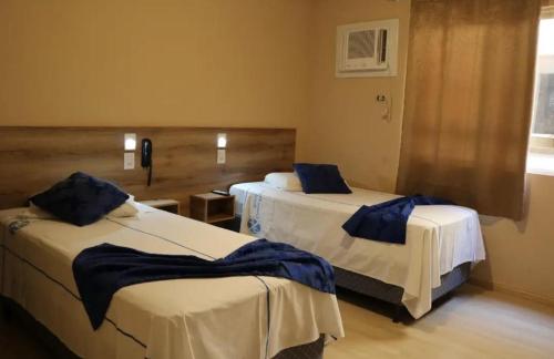 a room with two beds with blue pillows on them at Exito in Guarulhos