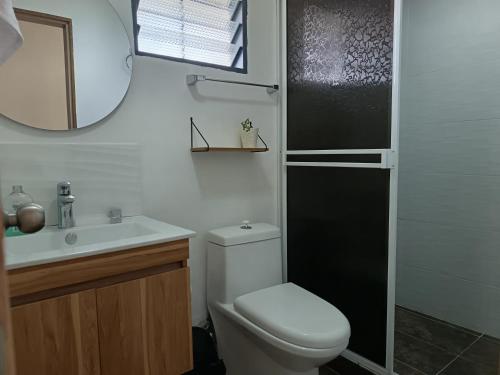 ein Badezimmer mit Toilette, Waschbecken und Spiegel in der Unterkunft Panorama Café Hostel in Buenavista