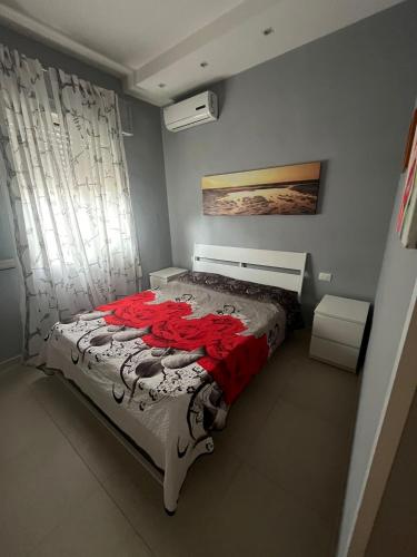 una camera da letto con un letto con un vestito rosso sopra di Villa Miglietta a Torre Lapillo