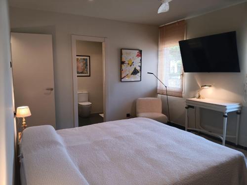 a bedroom with a bed and a flat screen tv at Villa D'or in Madrid