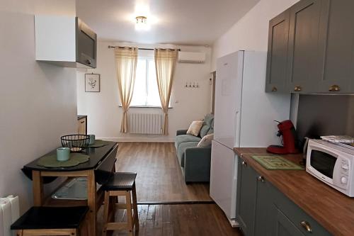 ImphyLe Havre de Sauge的厨房以及带沙发和微波炉的客厅。