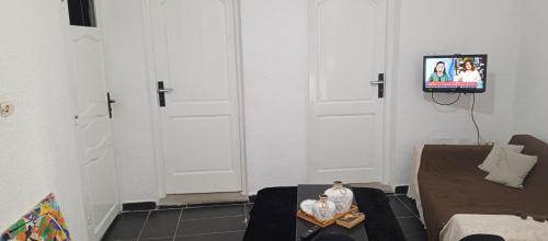 a room with a tv and two statues on a table at Chambre single in Tunis