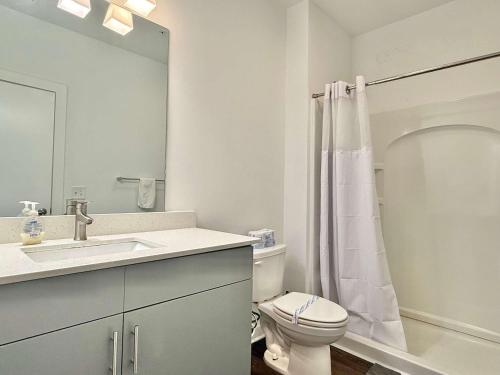 a white bathroom with a toilet and a sink at Luxury New 2B2B Private Balcony 542Blvd in Atlanta