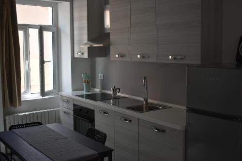 a kitchen with a sink and a refrigerator at Vittoria Residence in Serravalle Scrivia