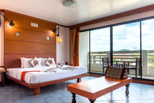 a hotel room with a bed and a large window at Hua Hin Loft in Hua Hin