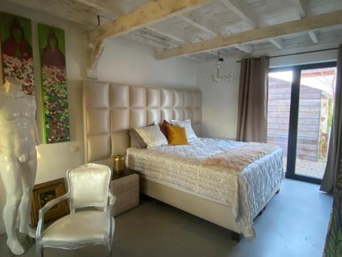 a bedroom with a large bed and a chair at Guest Rooms by Art Bruges in Jabbeke