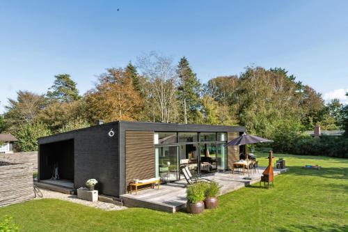 Vejby StrandIndulgence In Architect-Designed House In Vejby的花园里的一座小黑屋